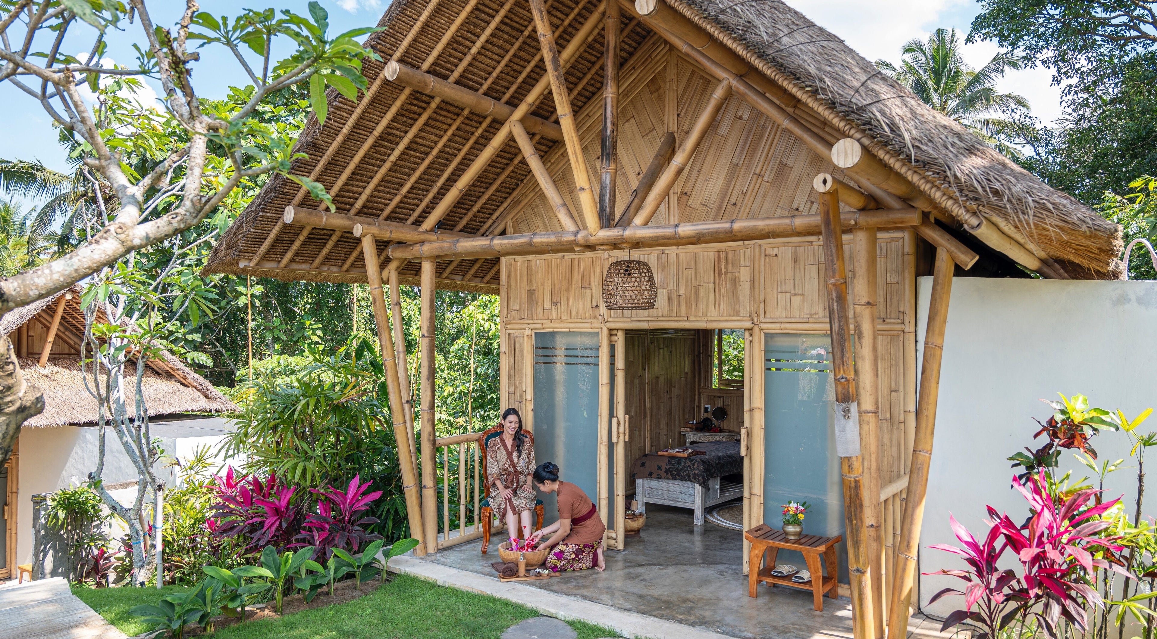 Peaceful bamboo spa hut at Visesa Spa, Bali, Bali, ID, surrounded by lush greenery and blooming flowers.