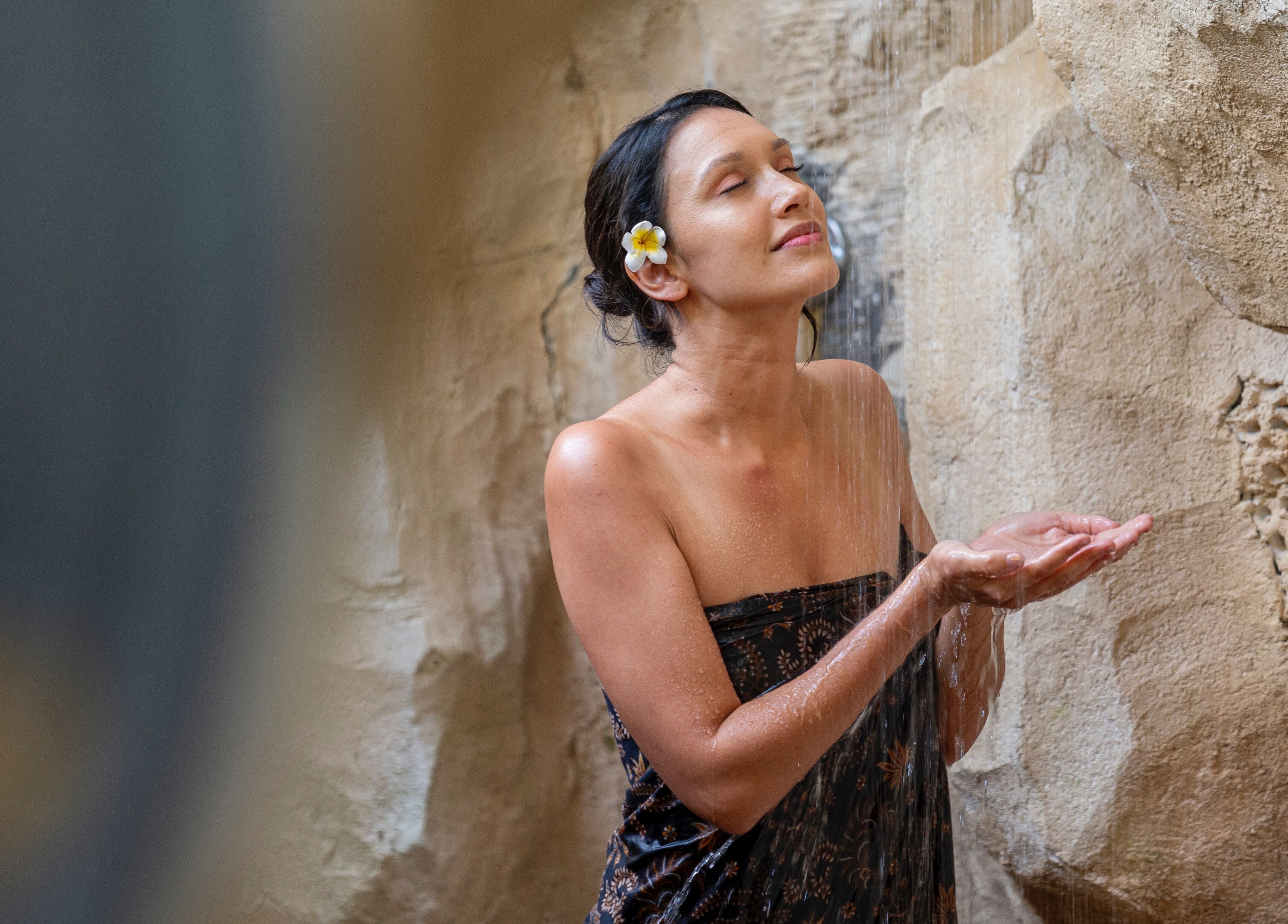A woman enjoys a tranquil shower at Visesa Spa, Bali, Bali, ID, showcasing relaxation and rejuvenation.
