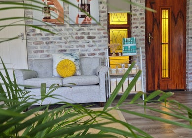 Cozy lounge at Flourish Skincare and Beauty Studio, Gqeberha, featuring plush sofa and skincare products.