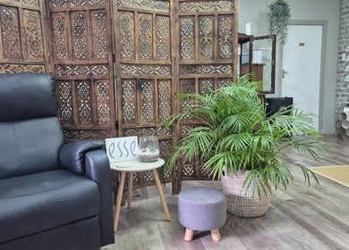 Relaxing corner at Flourish Skincare and Beauty Studio, Gqeberha, features armchair, plant, and wooden decor.