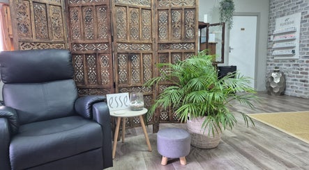 Relaxing corner at Flourish Skincare and Beauty Studio, Gqeberha, features armchair, plant, and wooden decor.