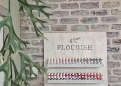 Flourish Skincare and Beauty Studio in Gqeberha, Eastern Cape, ZA with a chic product display on a rustic wall.