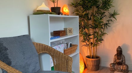 Cozy relaxation corner at Natalie Jane Wellbeing, Malmesbury, England, GB with chair, plant, and decor.