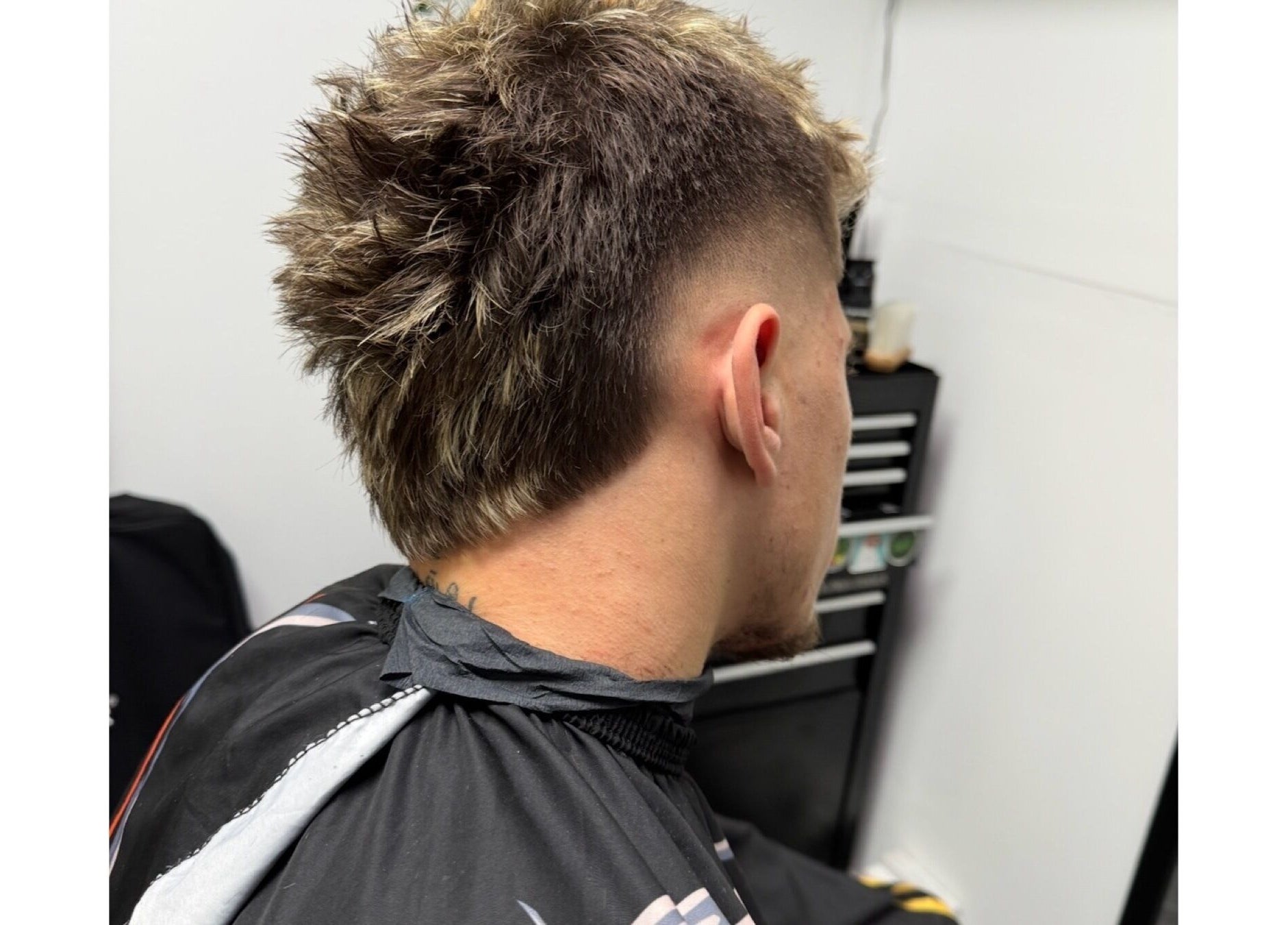 Trendy haircut with a fade at Haychs Hair Barbershop in Horsham, England, GB.