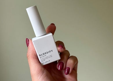 Hand holding a Glossify nail polish bottle at Nails By Georgie in Royal Tunbridge Wells, England, GB.