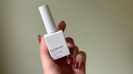 Hand holding a Glossify nail polish bottle at Nails By Georgie in Royal Tunbridge Wells, England, GB.
