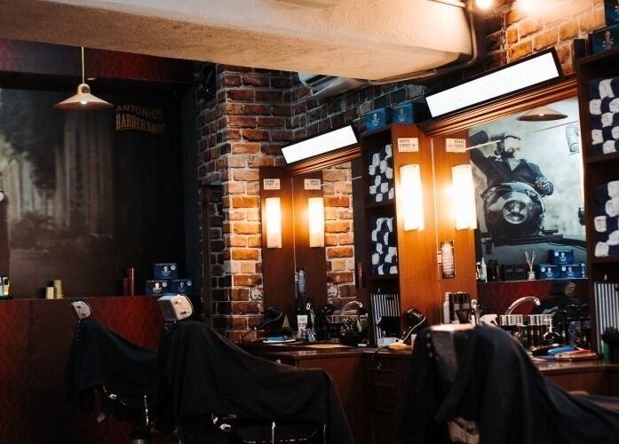 Inside Antonio's Barbershop Balzan, warm lighting and vintage decor create a welcoming ambiance in Ħal Balzan, MT.