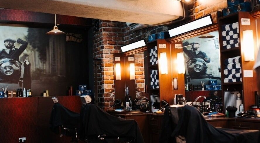 Inside Antonio's Barbershop Balzan, warm lighting and vintage decor create a welcoming ambiance in Ħal Balzan, MT.