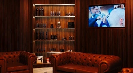 Elegant lounge at Antonio's Signature Mriehel in Birkirkara, MT, featuring leather seating and shelving.