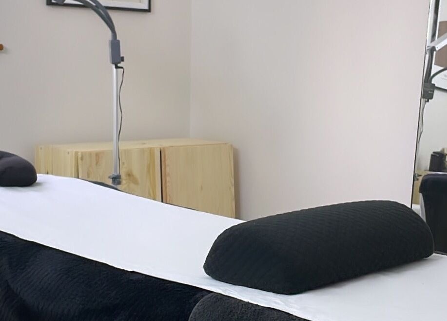 Relaxing massage room at Pluck’d Hornchurch in Hornchurch, England, GB with cozy bed and modern decor.