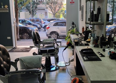 Interno moderno di Domus Barber Gregorio VII a Roma, Lazio, IT con sedie eleganti e attrezzature da barbiere.