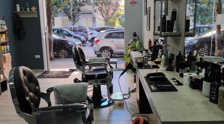 Interno moderno di Domus Barber Gregorio VII a Roma, Lazio, IT con sedie eleganti e attrezzature da barbiere.
