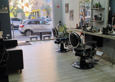 Interno di Domus Barber Gregorio VII a Roma, Lazio. Ambiente moderno e accogliente con sedie e specchi eleganti.