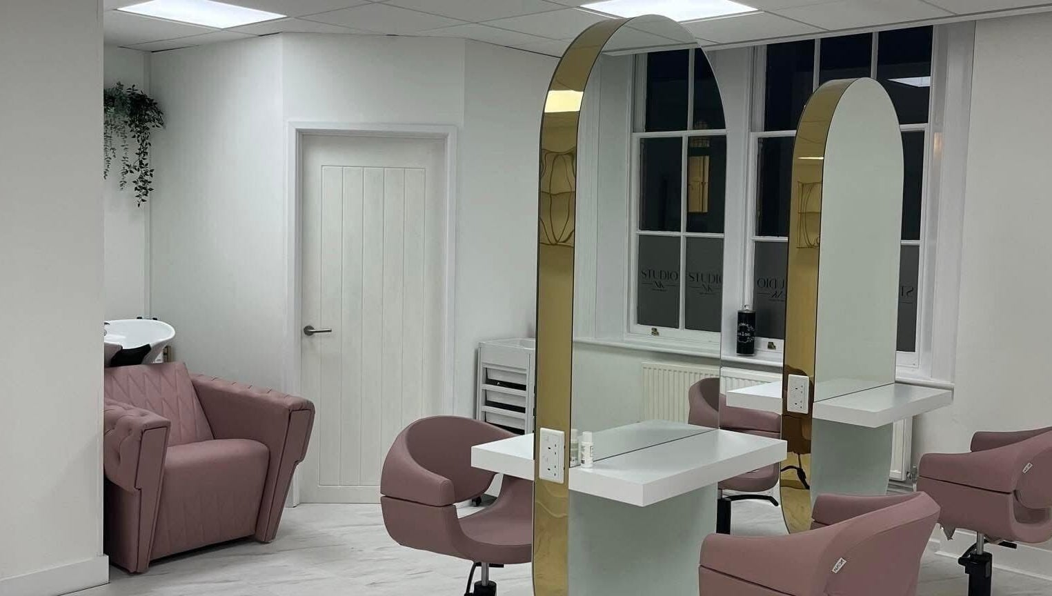 Elegant interior with pink chairs at Studio NK, Newbury, England, GB. Modern mirrors and sleek design.