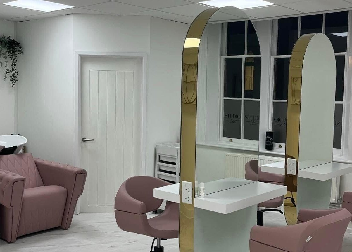 Elegant interior with pink chairs at Studio NK, Newbury, England, GB. Modern mirrors and sleek design.