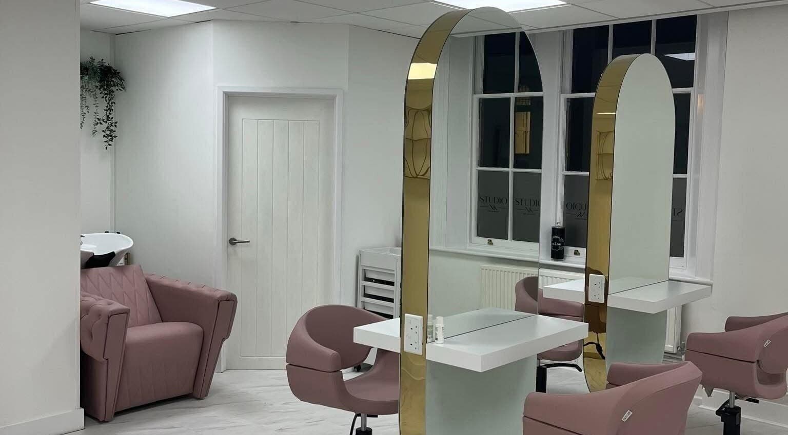 Elegant interior with pink chairs at Studio NK, Newbury, England, GB. Modern mirrors and sleek design.