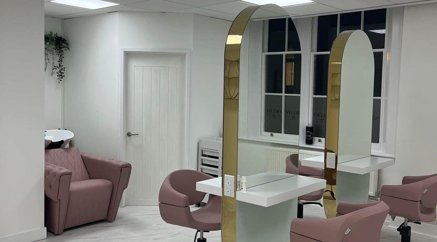 Elegant interior with pink chairs at Studio NK, Newbury, England, GB. Modern mirrors and sleek design.