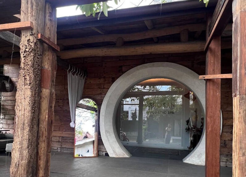 Entrance of Shosan Holistic Spa in Bali, Bali, ID featuring rustic wooden elements and circular door.