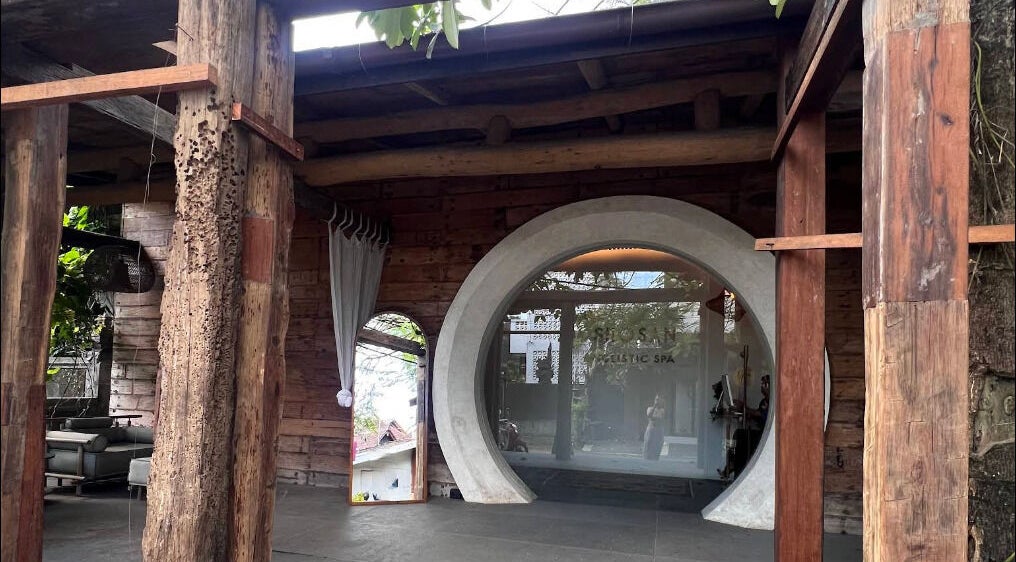 Entrance of Shosan Holistic Spa in Bali, Bali, ID featuring rustic wooden elements and circular door.