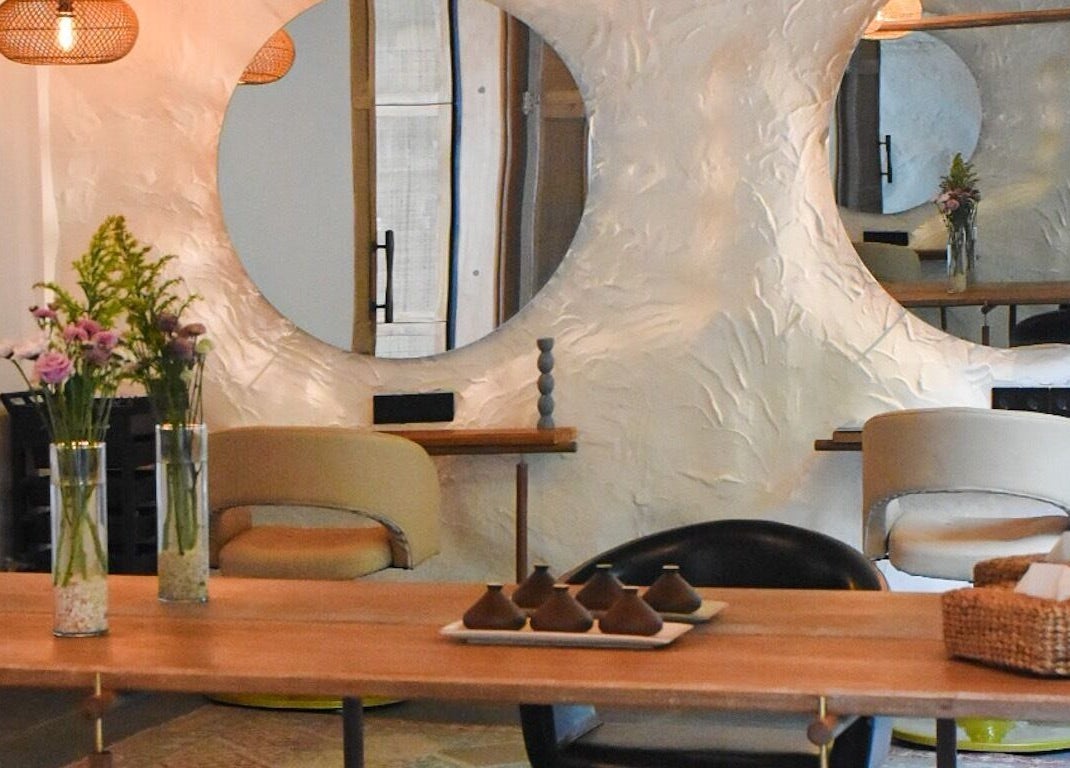 Elegant seating area at Shosan Holistic Spa in Bali, Bali, ID with mirrors and floral decor.