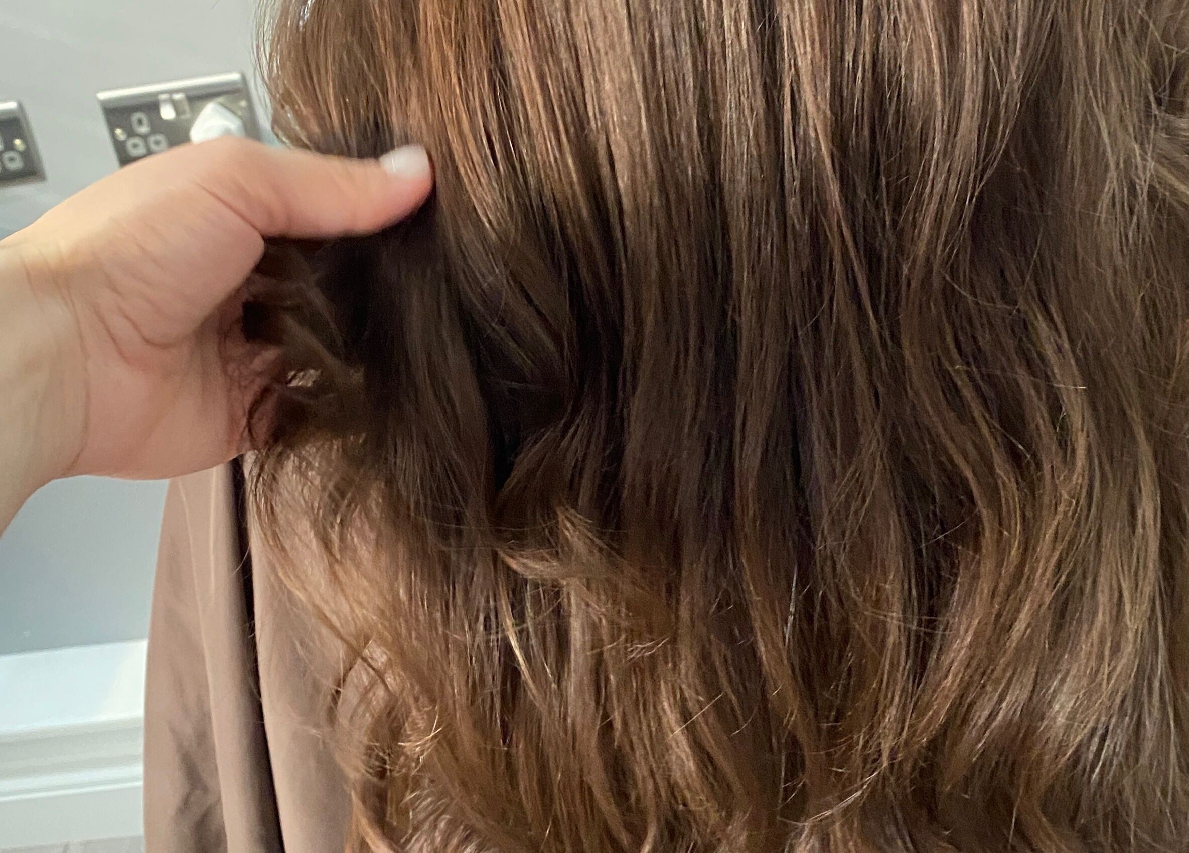Stylish brown wavy hair being styled at HairMatters by Mariana in Feltham, England, GB.