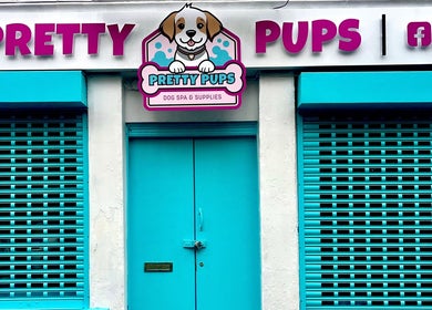Pretty Pups Dog Spa entrance in Gourock, Scotland, GB with vibrant blue shutters and signage.
