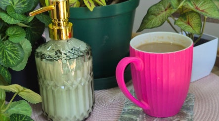 Radiant Blossom - Pretoria North: Pink mug and soap dispenser amidst lush plants, Pretoria, Gauteng, ZA.
