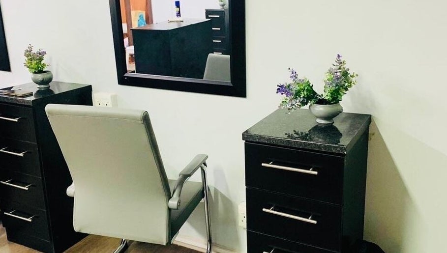 Modern salon chair and dresser at Entlestylist, East London, Eastern Cape, ZA. Sleek design with decorative plants.