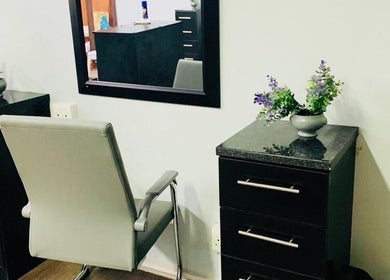 Modern salon chair and dresser at Entlestylist, East London, Eastern Cape, ZA. Sleek design with decorative plants.