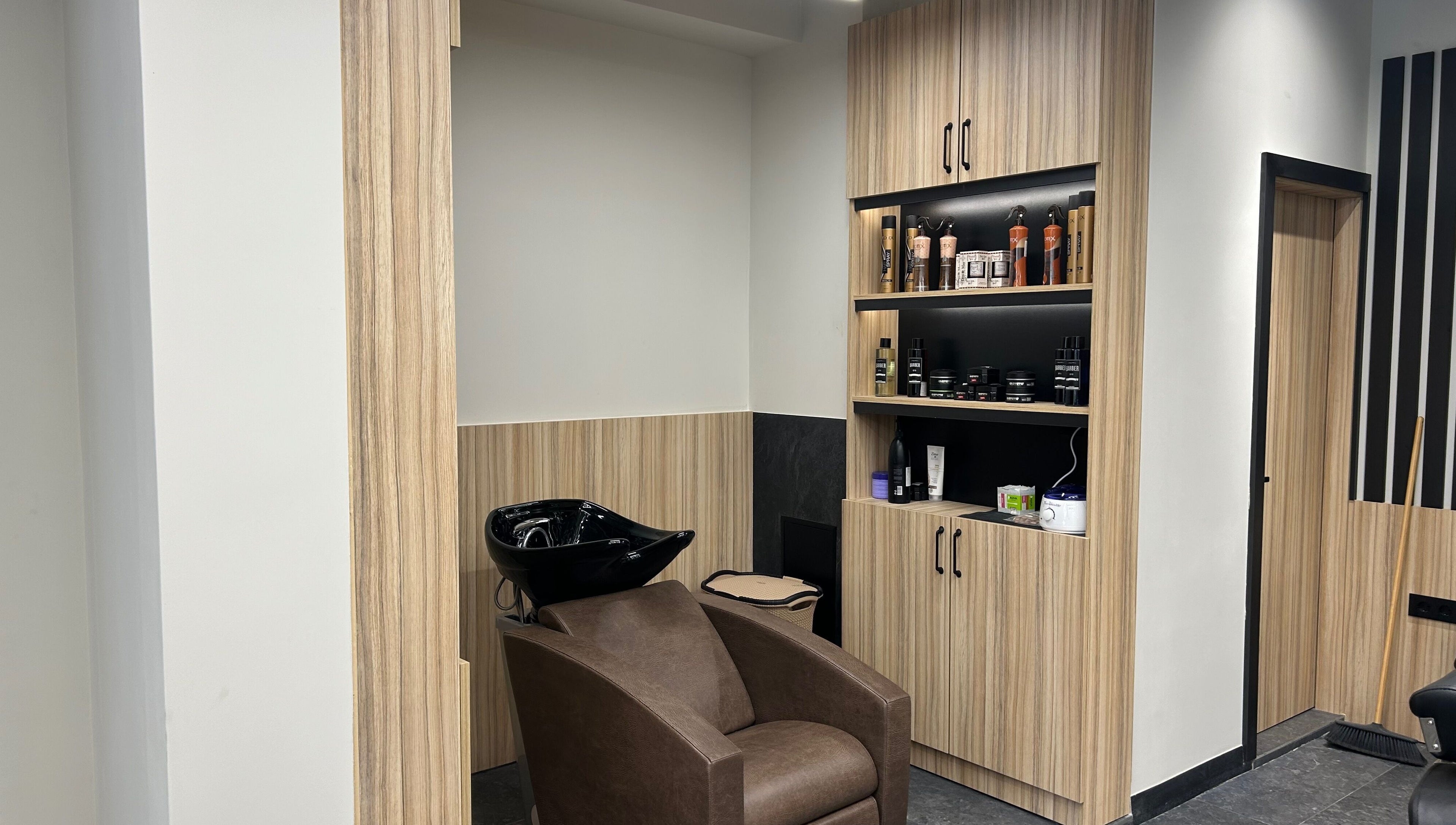 Sleek washing station at Galaxy Barbershop, Sofia, Sofia City Province, BG with shelves of products.
