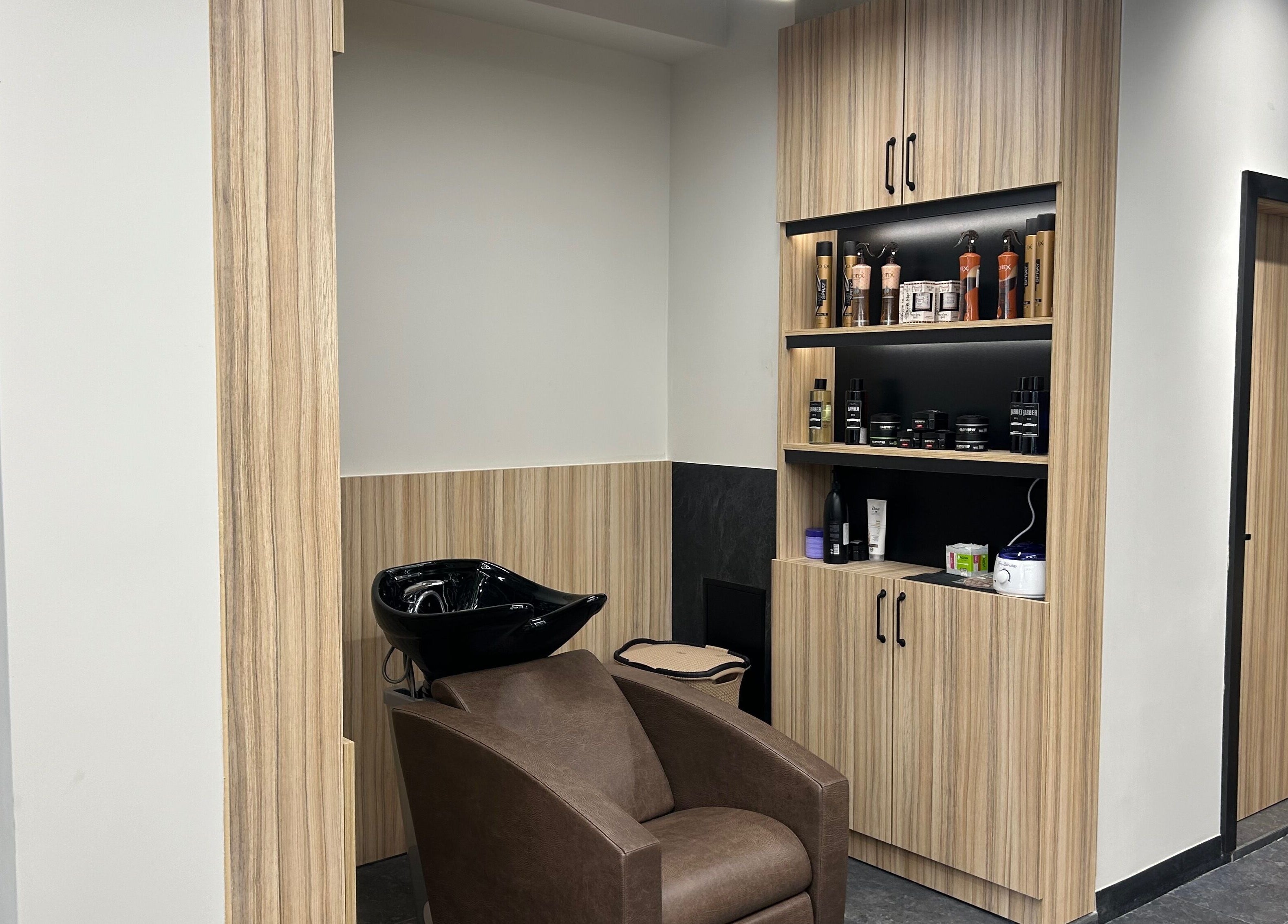 Sleek washing station at Galaxy Barbershop, Sofia, Sofia City Province, BG with shelves of products.