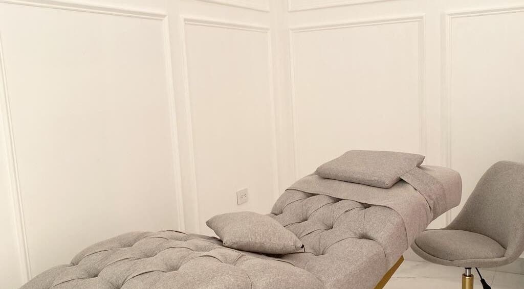 Sala de tratamiento en Althea Beauty Bar, Durango, Durango, MX, con silla gris y camilla cómoda.