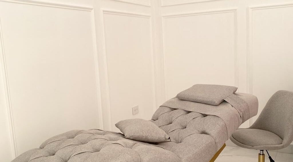 Sala de tratamiento en Althea Beauty Bar, Durango, Durango, MX, con silla gris y camilla cómoda.