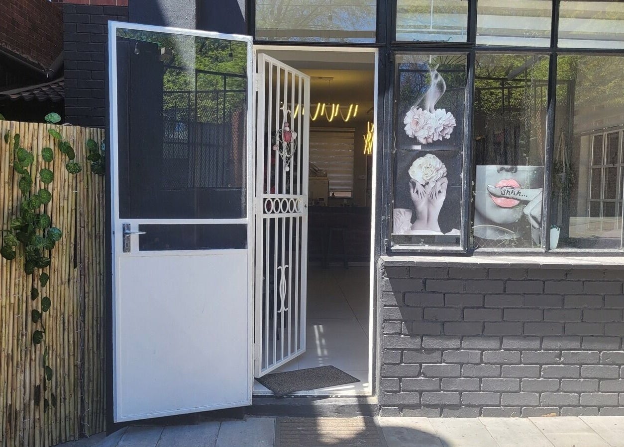 Entrance of Divine Sparkle beauty salon in Randburg, Gauteng, ZA with decorative art on the window.