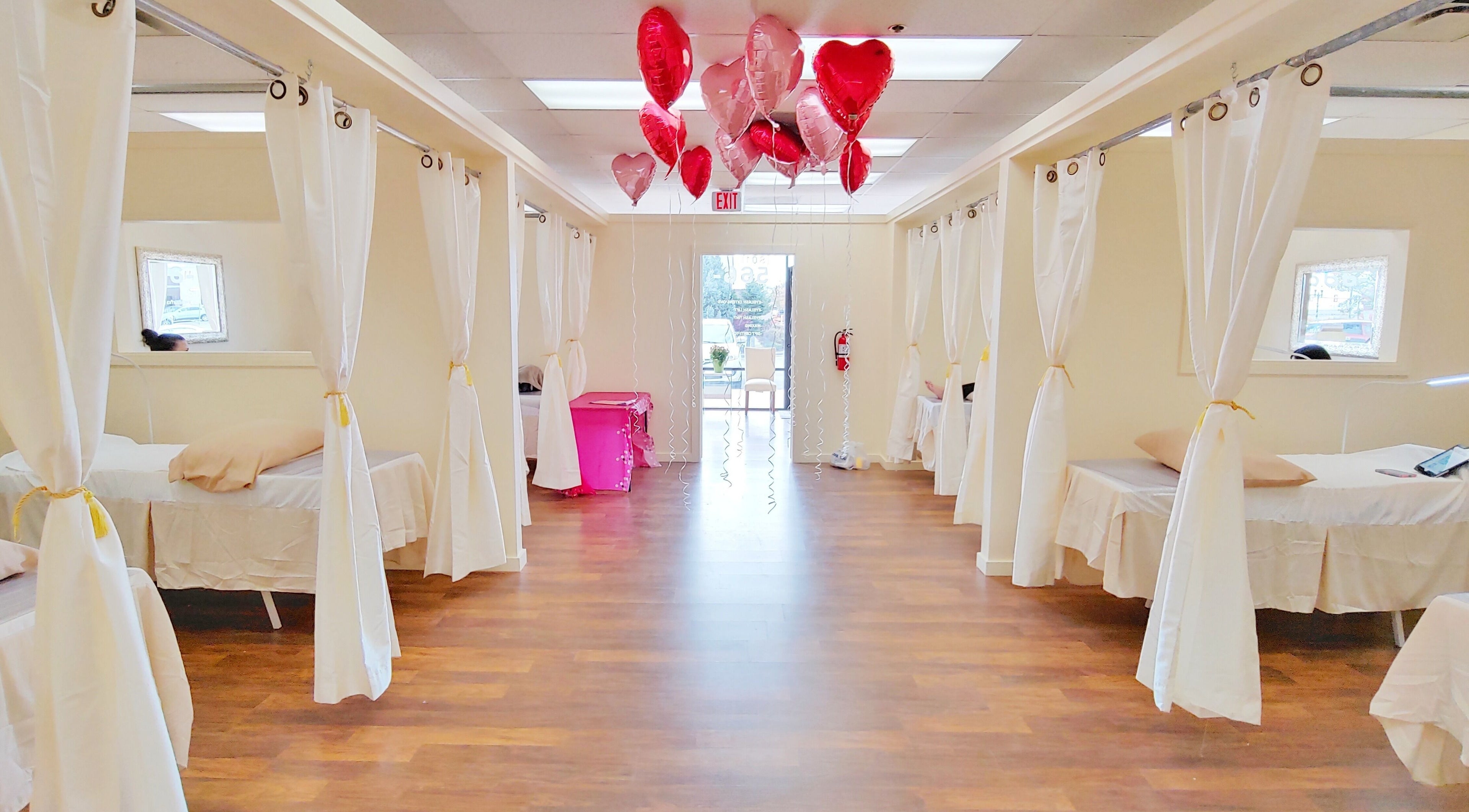 Elegant interior of Star Lash Studio-Sandy, Utah, US with balloons and curtained treatment beds.