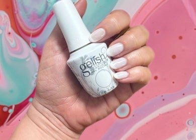 Elegant hand with gel polish bottle at Nadine's Nail & Beauty Bar Techno Park Stellenbosch, Western Cape, ZA.