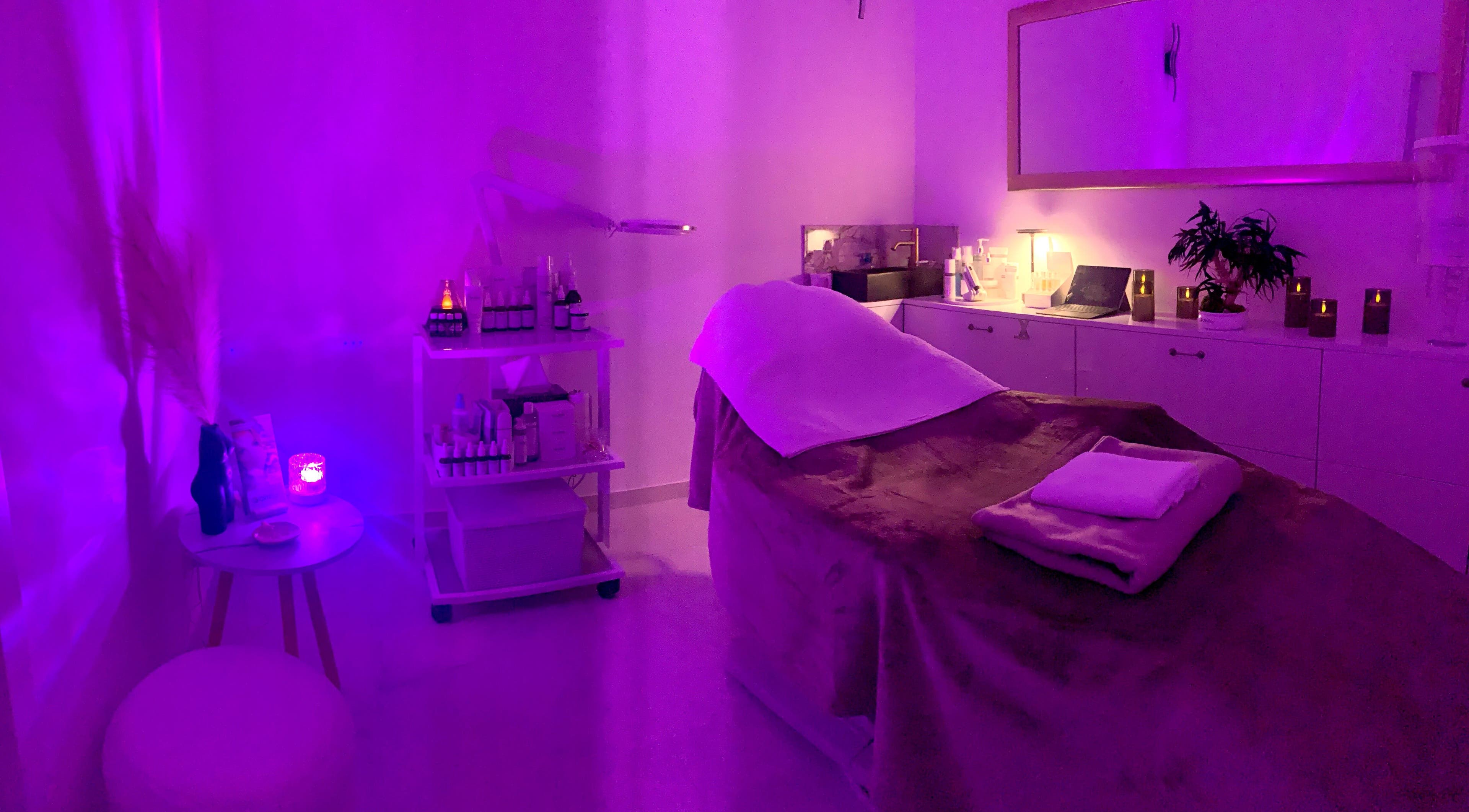 Pohodlné relaxační lůžko v salonu Cosmetologist - Therapist Maryna Vainberh, Bratislavský Kraj, SK, v tlumeném fialovém osvětlení.