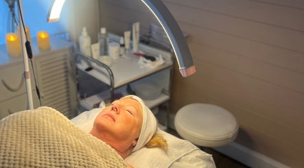 Client relaxing during a facial at Jayme’s Home Studio, Hornchurch, England, GB under soft lighting.