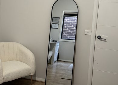 Elegant corner at Victoria Makeup Artistry in Mickleham, Victoria, AU featuring a mirror and cozy chair.