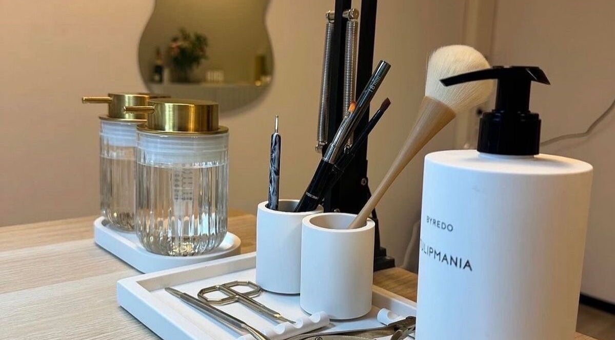 Mesa de herramientas de belleza en Blue Studio, Maracaibo, Zulia, VE, con dispensadores elegantes y pinceles de maquillaje.