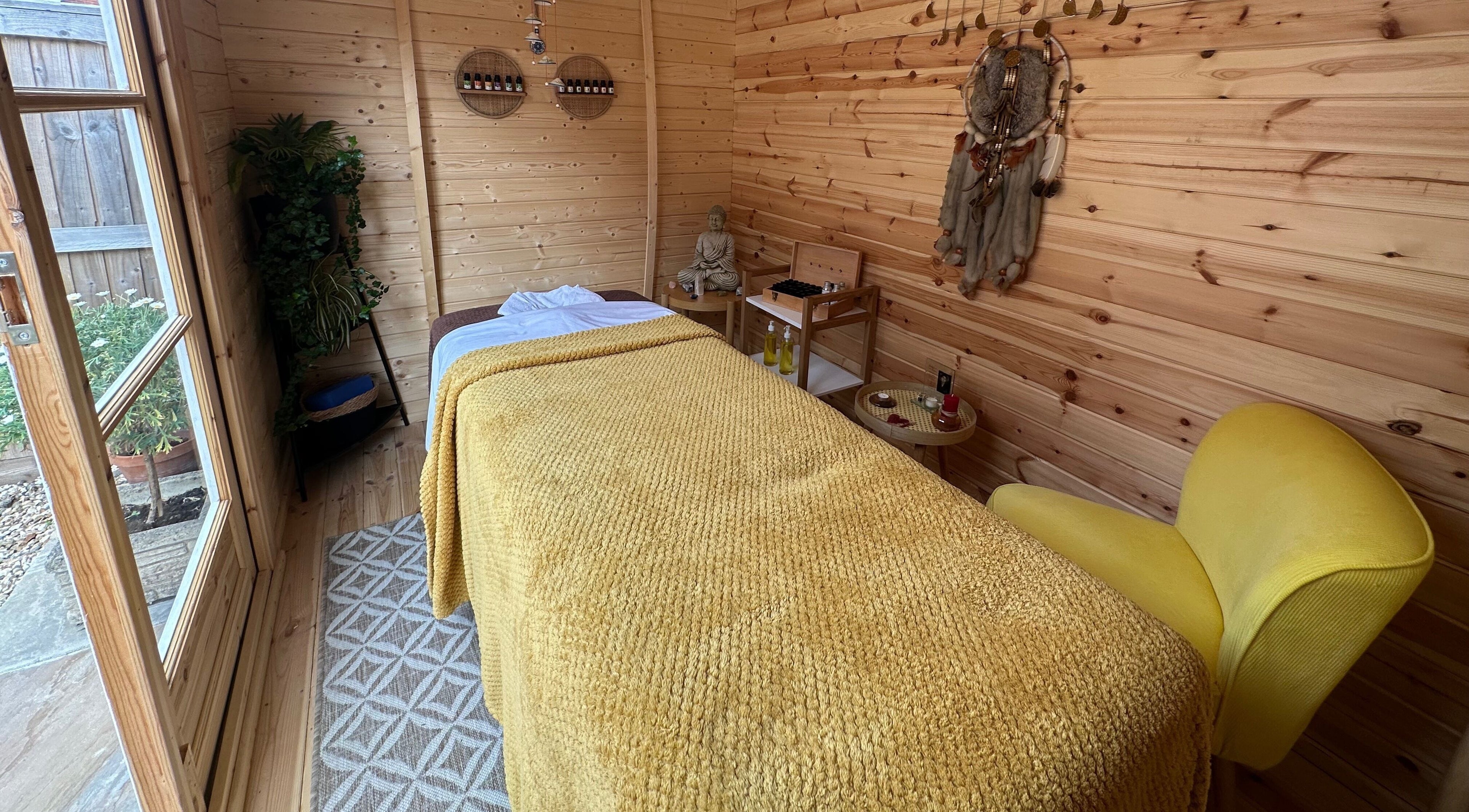 Peaceful massage room at Awaken Massage Therapies, Trowbridge, England, GB with cozy wooden decor and yellow accents.