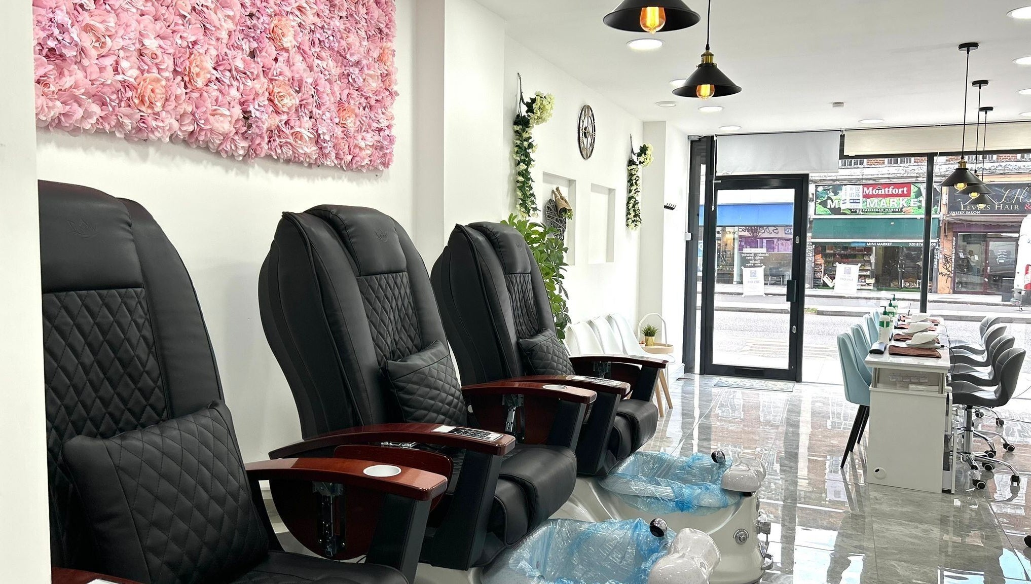 Luxurious pedicure chairs at Blissful Nail Studio, London, England, GB, with elegant floral wall decor.
