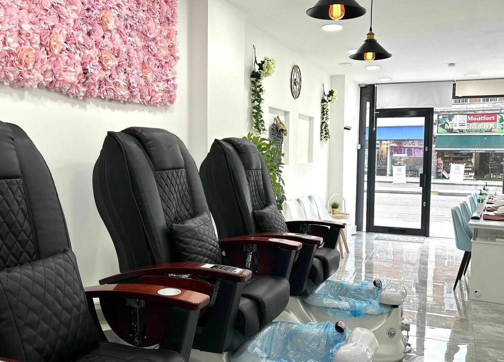 Luxurious pedicure chairs at Blissful Nail Studio, London, England, GB, with elegant floral wall decor.