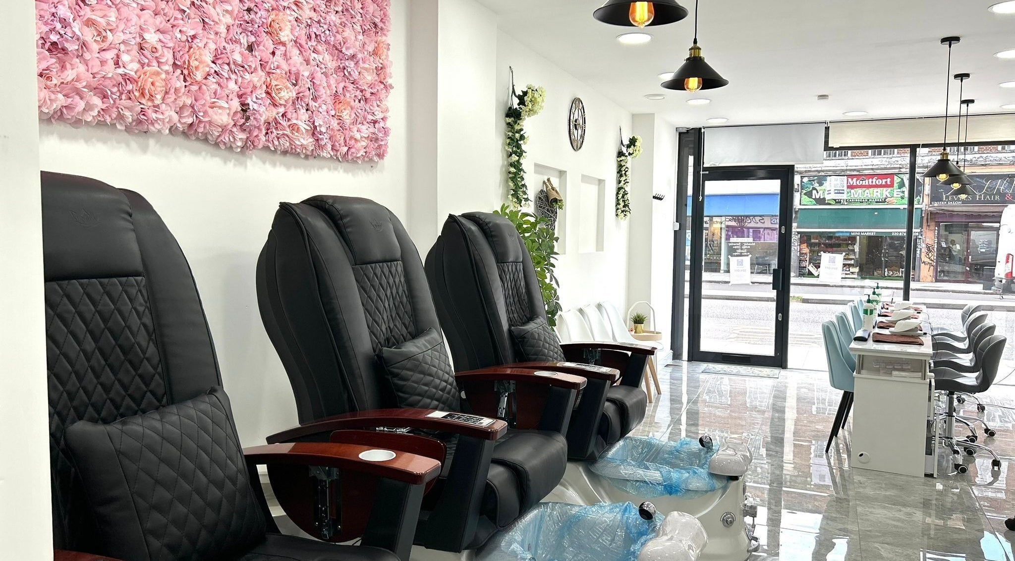 Luxurious pedicure chairs at Blissful Nail Studio, London, England, GB, with elegant floral wall decor.