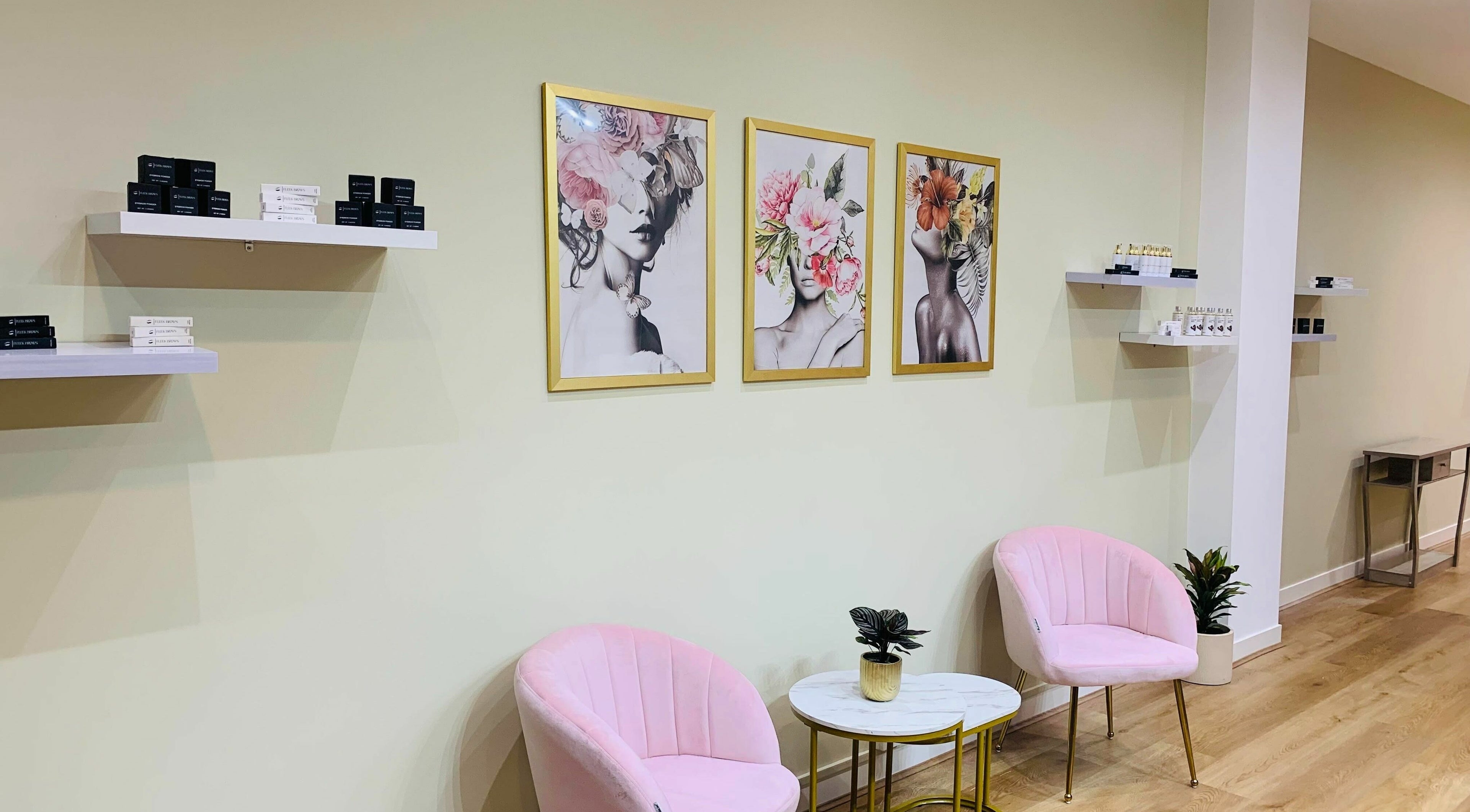 Chic lounge at Fleek Brows, Prahran, Victoria with art and pink chairs.