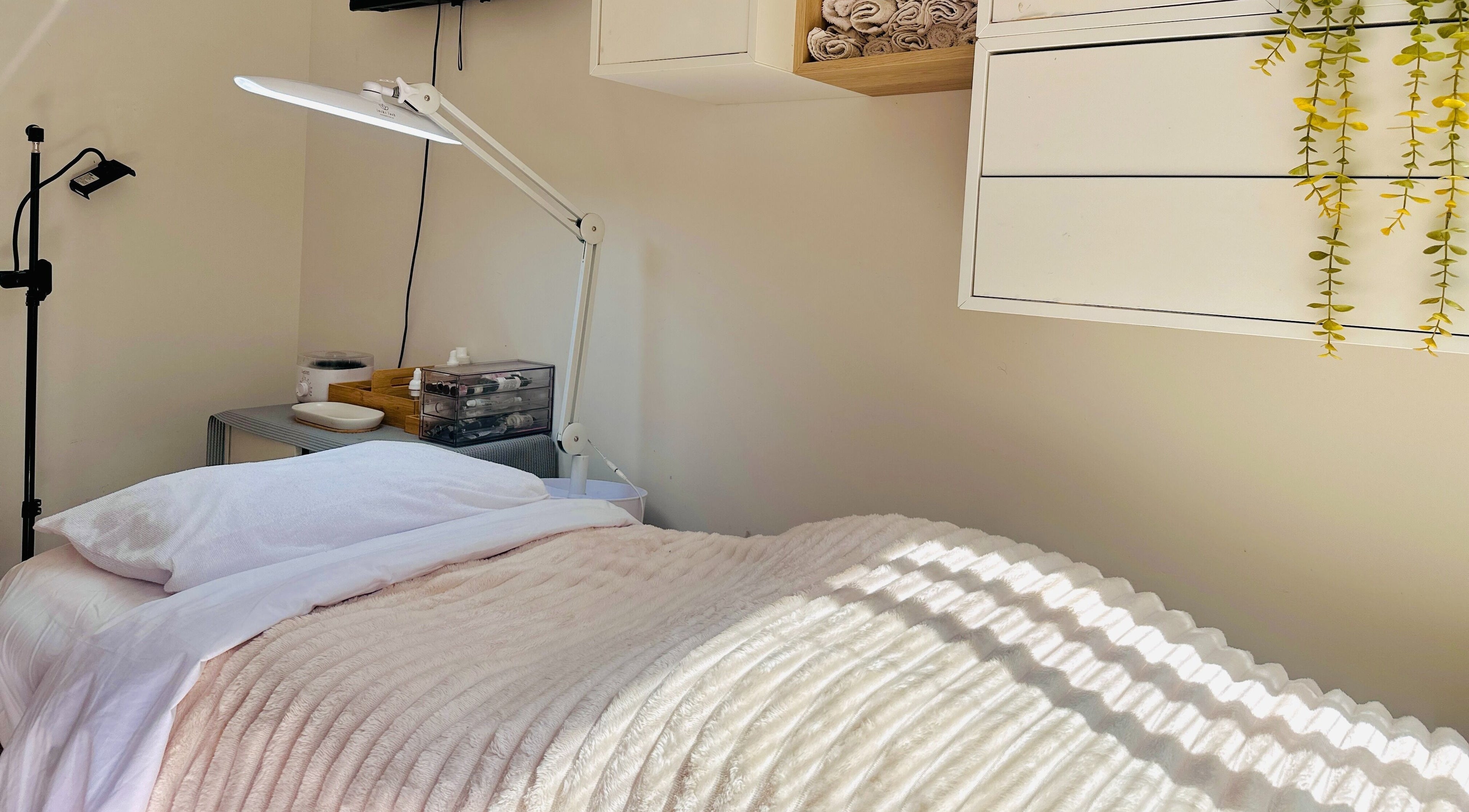 Cozy treatment room at Nicole Beauty Studio, Caversham, WA with soft lighting and plush bedding.
