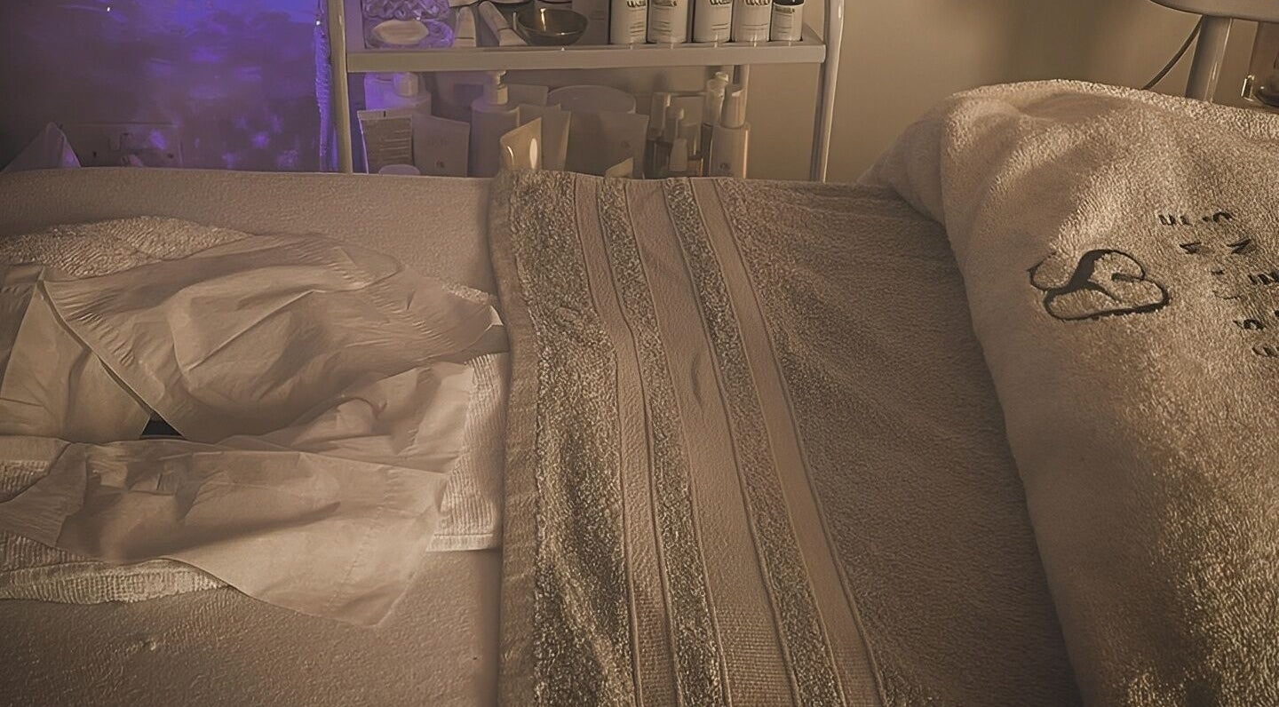 Relaxing spa bed setup at The Beauty Hideout in Goosnargh, England, GB, with towels and soft lighting.