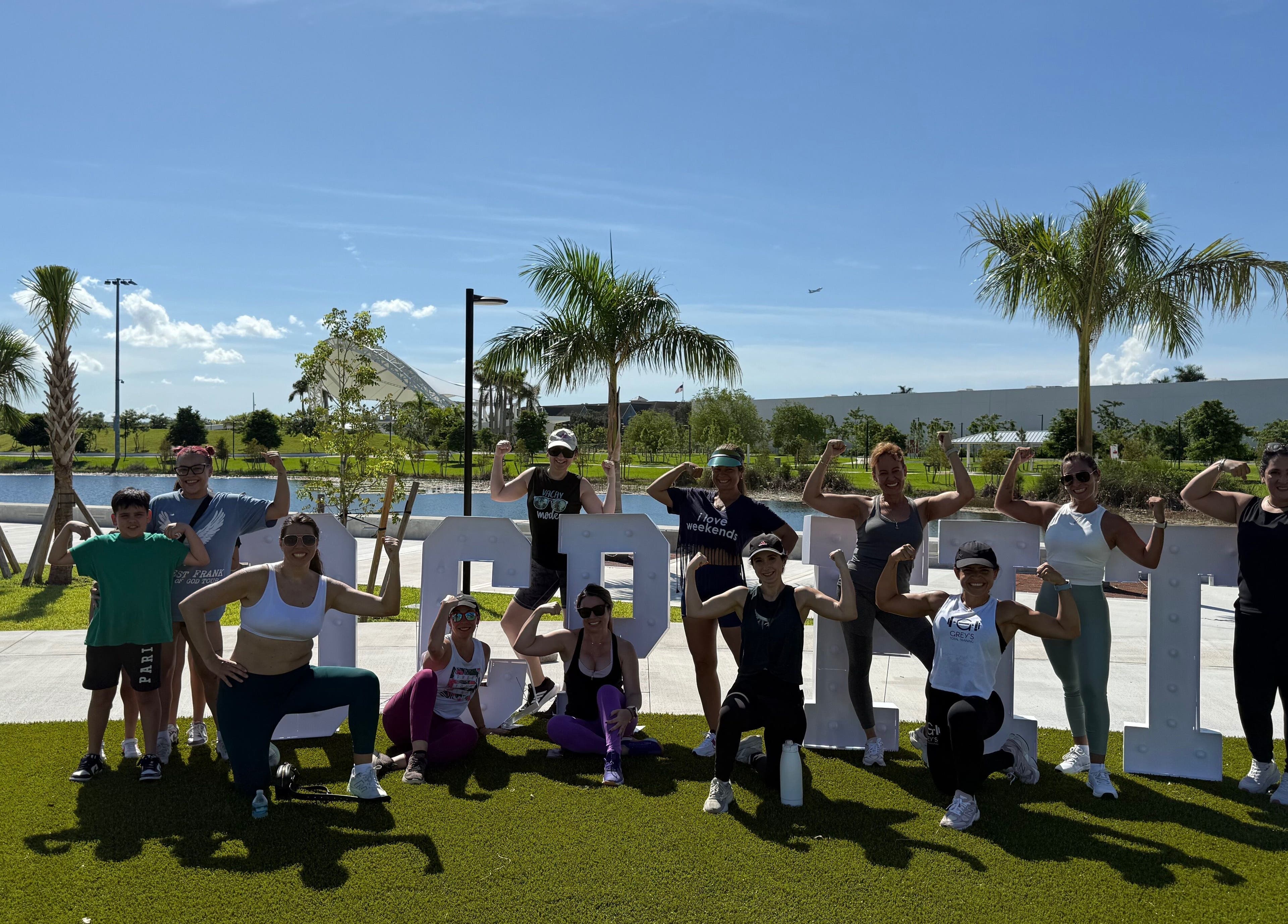 Group fitness session at Grey’s Total Training, Miami, Florida, US. Participants flexing muscles and enjoying the outdoors.