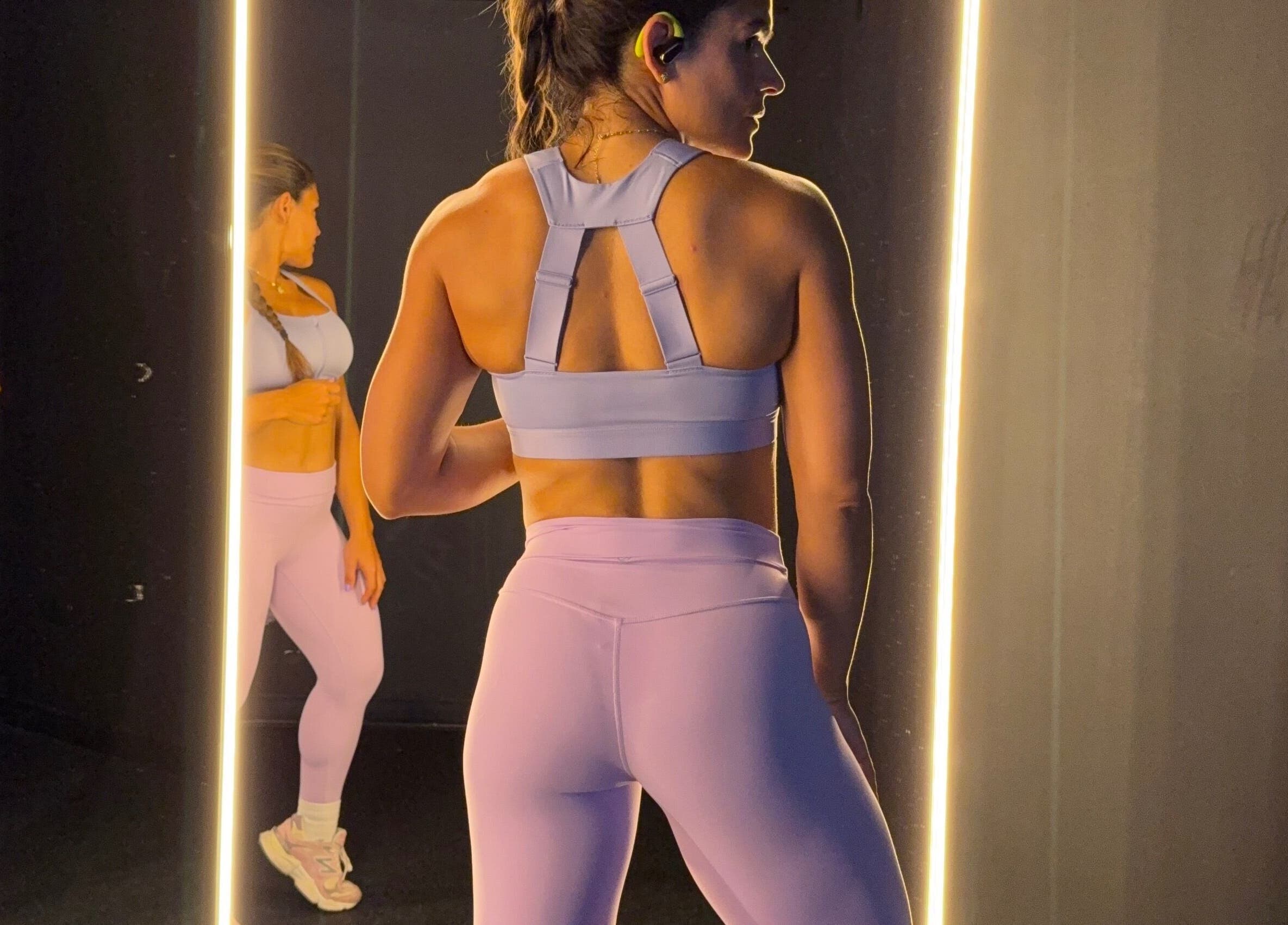 Woman exercising at Grey’s Total Training gym in Miami, Florida, US, using mirror reflections to perfect her form.