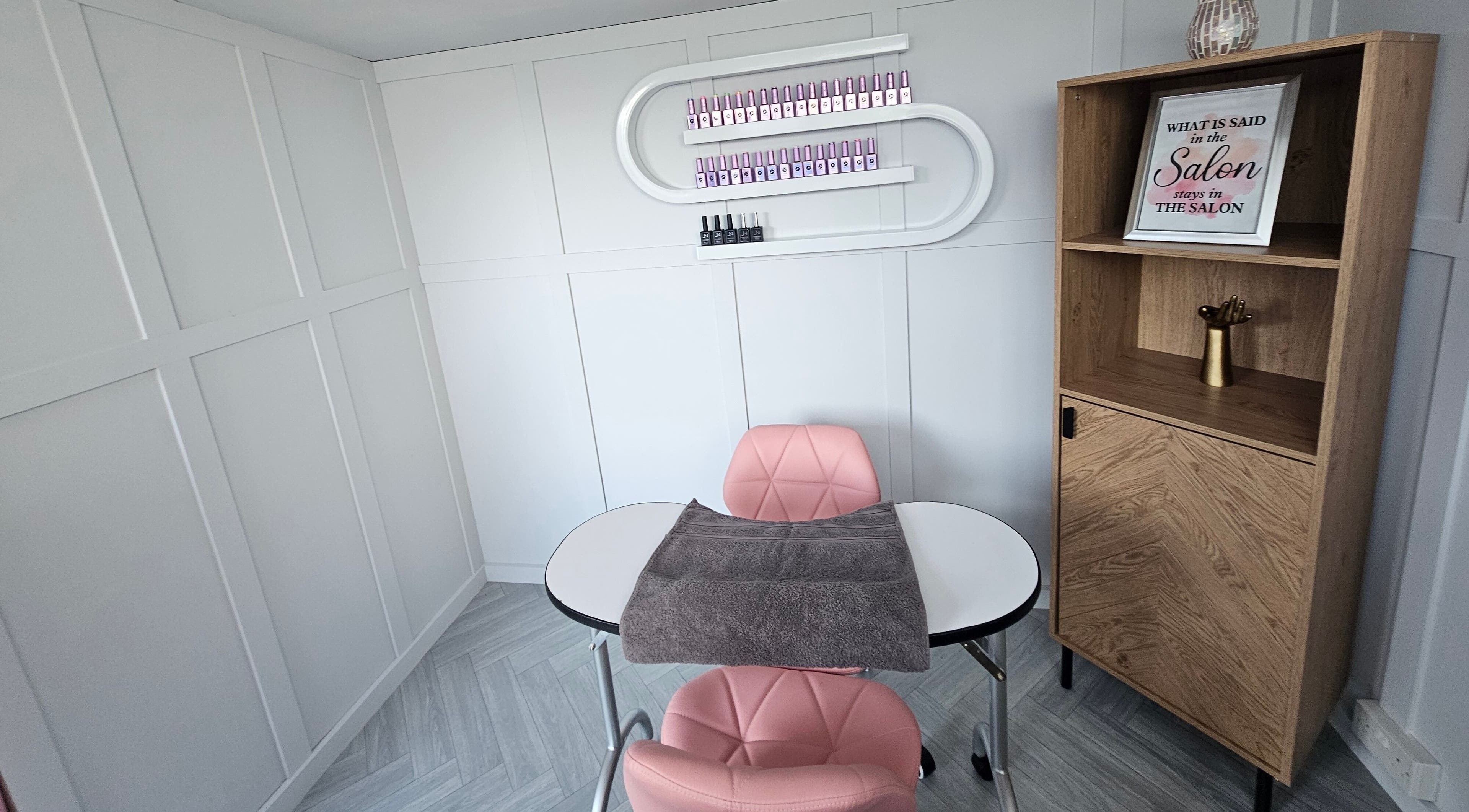 Elegant manicure station at Bella Tu, Haverhill, England, GB, featuring pink chairs and modern decor.